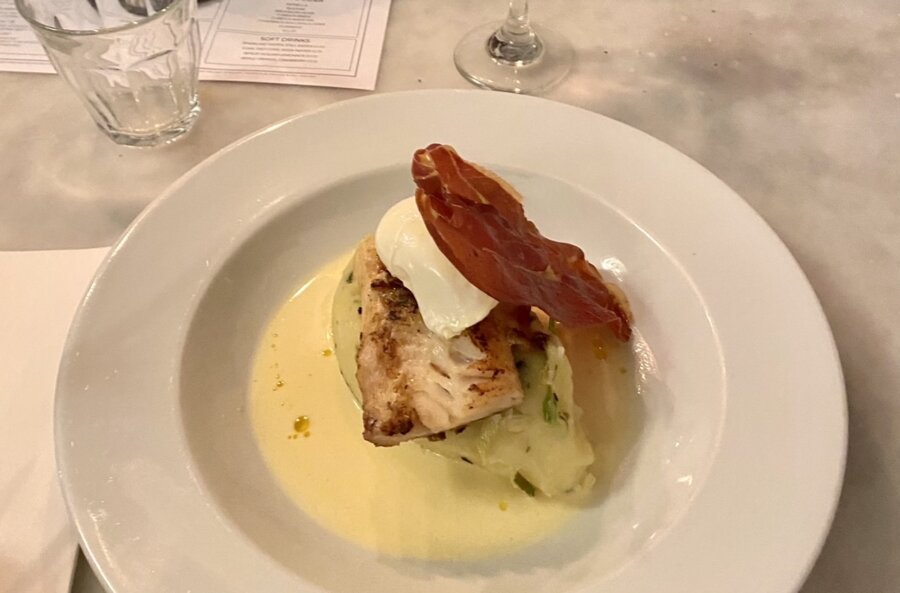 Piatto con un’orata, un uovo e una fetta di prosciutto